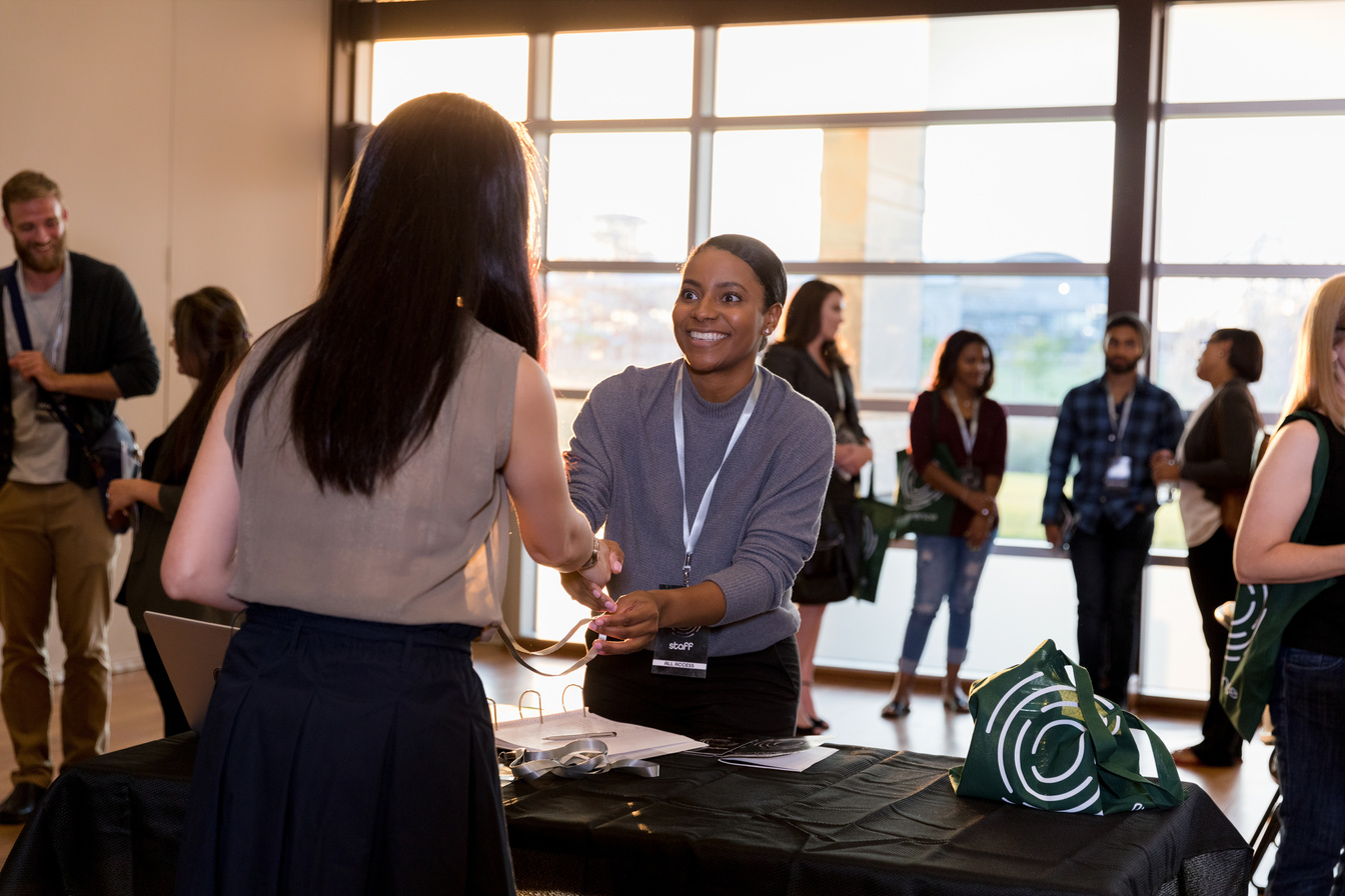 Smiling woman greets conference attendee